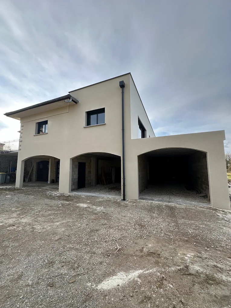 Maison à façade claire avec trois ouvertures en arc au rez-de-chaussée